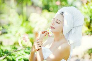 beautiful woman in towel with flower in her hand photo