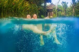 dos mujer nadando en el piscina a un recurso foto