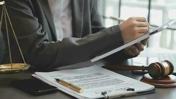 concepto de justicia y derecho. juez masculino en una sala de audiencias con el mazo, trabajando con computadora y teclado de acoplamiento, anteojos, en la mesa a la luz de la mañana video