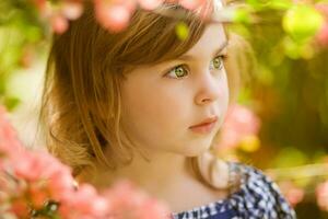 un pequeño niña en un a rayas vestir en pie en un campo de lavanda foto