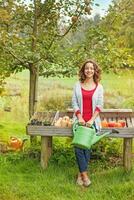 a woman is sitting on a bench with a watering can photo