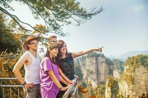 four people standing on a bridge overlooking the mountains photo