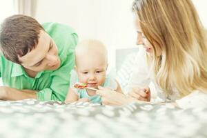 Parents offering their baby a candy photo