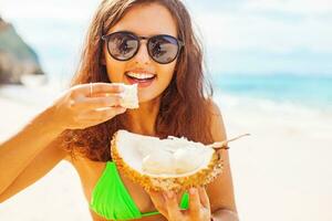 mujer comiendo Durian en un playa atención en su manos foto