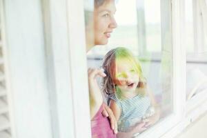 Mother and daughter looking through the window focus on the face of childr photo