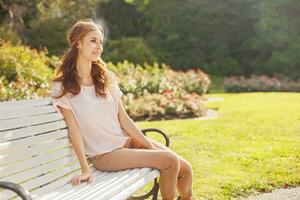 a woman sitting on a bench in a park photo