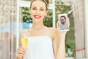 un mujer participación un vaso de naranja jugo y un selfie foto