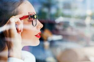 a woman wearing glasses looking out the window photo