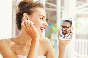 un mujer participación arriba un teléfono con un hombre en eso foto