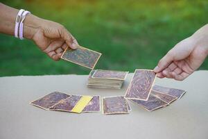 Close up hands choose and pick  up paper cards. concept, fortune reading. astrology. Foretelling, mystery, magic, fortune, fate. Prediction for future life ,events. photo