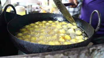 de cerca sentido de haciendo fritura buñuelos indio calle comida cuales es además conocido varios nombre me gusta Moong dal pakoda, Moong dal bhajiya, Moong dal vada, pakoda, bhajiya, aloo pakora, bhajiya, etc. video