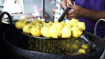 Close-up sense of Making Frying Fritters Indian Street food which is also known video