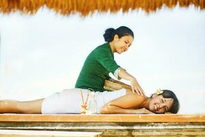 a woman getting a massage on the beach photo