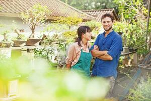 a man and woman standing in front of a garden photo