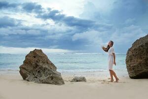 un mujer en pie en el playa foto