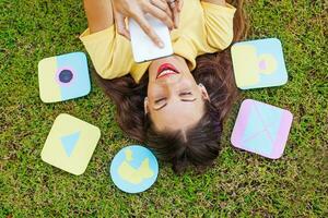 a woman laying on the grass with her phone and cards photo