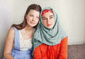 friendship of the religions concept muslim and christian girl together photo