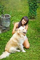 a woman sitting on the grass with a dog photo