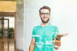 a man in glasses is holding something up photo