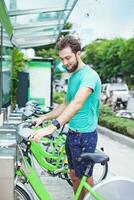 un hombre es en pie siguiente a un verde bicicleta foto