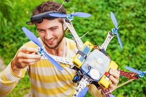 a man is holding a remote control drone in his hand photo