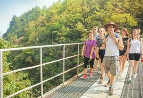 group of people walking on a bridge over a river photo