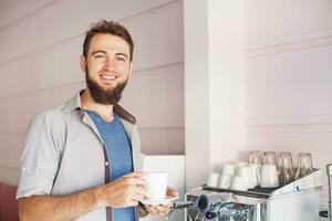a man is holding a cup of coffee photo