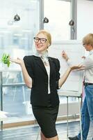 a woman in a business suit and glasses holding a plant photo