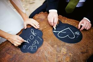 a bride and groom are holding chalkboards with hearts on them photo