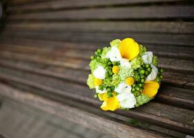 a wedding bouquet sitting on a wooden bench photo