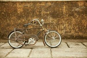 an old bicycle is parked against a wall photo