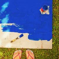 a person's feet on a blue paint board photo