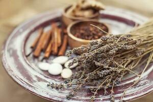 lavender, cinnamon, and other herbs are on a plate photo