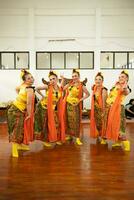 a group of traditional Javanese dancers having fun with their friends on stage after the performance ended photo