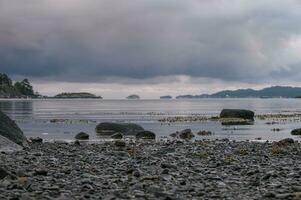 un temprano verano Mañana en fiordo de arena, Noruega con grueso nubes colgando terminado el fiordo. foto