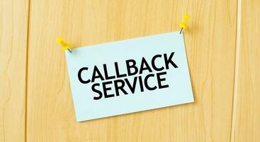 CALLBACK SERVICE sign written on sticky note pinned on wooden wall photo