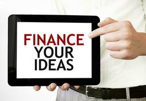 Text FINANCE YOUR IDEAS on tablet display in businessman hands on the white background. Business concept photo