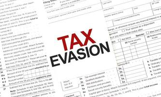 TAX EVASION words on paper sheet with documents photo