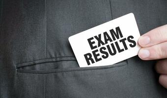 Card with EXAM RESULTS text in pocket of businessman suit. Investment and decisions business concept. photo