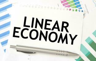 LINEAR ECONOMY on paper sheet on charts photo