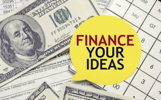Finanzas tu ideas palabras en amarillo pegatina con dolares y cartas foto
