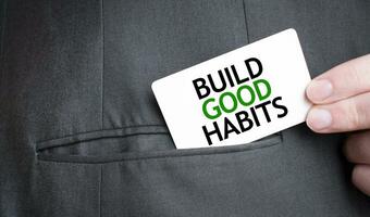 Card with BUILD GOOD HABITS text in pocket of businessman suit. Investment and decisions business concept. photo