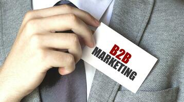 Businessman putting a card with text b2b marketing in the pocket photo