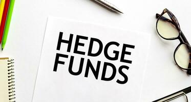 HEDGE FUNDS on paper sheet with glasses and pencils photo