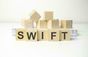 wooden cube block with swift business word on table background. photo