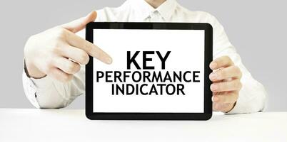 texto llave actuación indicador en tableta monitor en empresario manos en el blanco antecedentes. negocio concepto foto