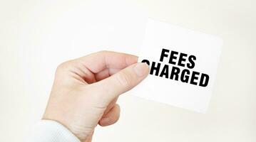 Businessman holding a card with text FEES CHARGED business concept photo