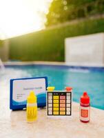 PH tester for pool maintenance. Water test kit for swimming pools, Chlorine and ph tester for swimming pools. Chlorine test kit on the edge of the pool photo