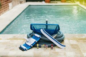 Image of pool cleaning and maintenance kit, vacuum cleaner, ph test, leaf picker and pool sweeper, Pool cleaning and maintenance tools photo