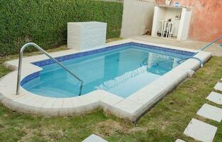 A blue swimming pool with a sand suction hose. A swimming pool with suction hose under water photo